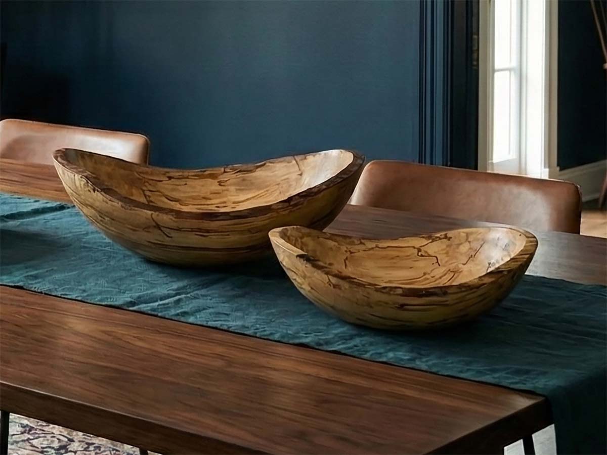 Live edge spalted maple oval bowls in 13-inch and 10-inch sizes displayed together on a wood dining table